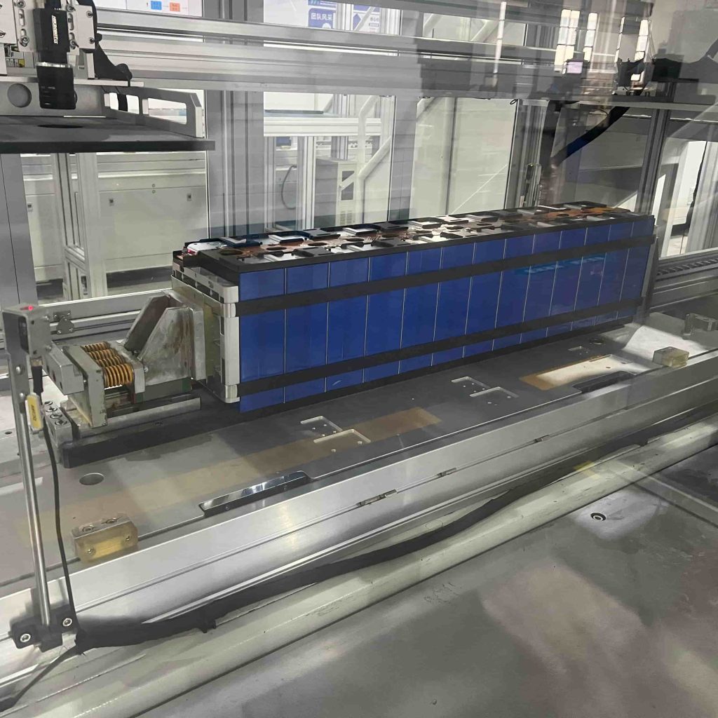 Close-up of a MegSolid hybrid solid-state battery module undergoing automated machine vision inspection on the manufacturing line.