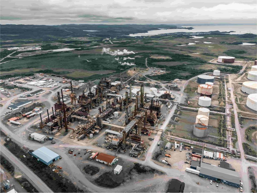 High-altitude drone shot of a massive industrial complex in Alberta under a cloudy sky, featuring processing towers, large storage tanks, and pipelines, integrated with a MegSolid C&I energy storage system.